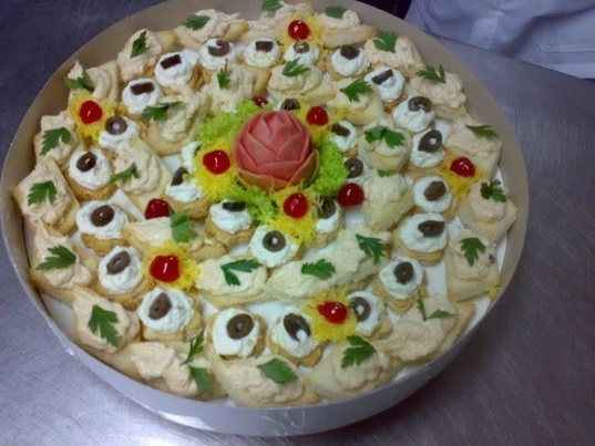Tábua de canapés decorada com flor de tomate ao centro